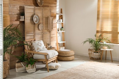 Stylish living room interior with comfortable wooden armchair and beautiful houseplants