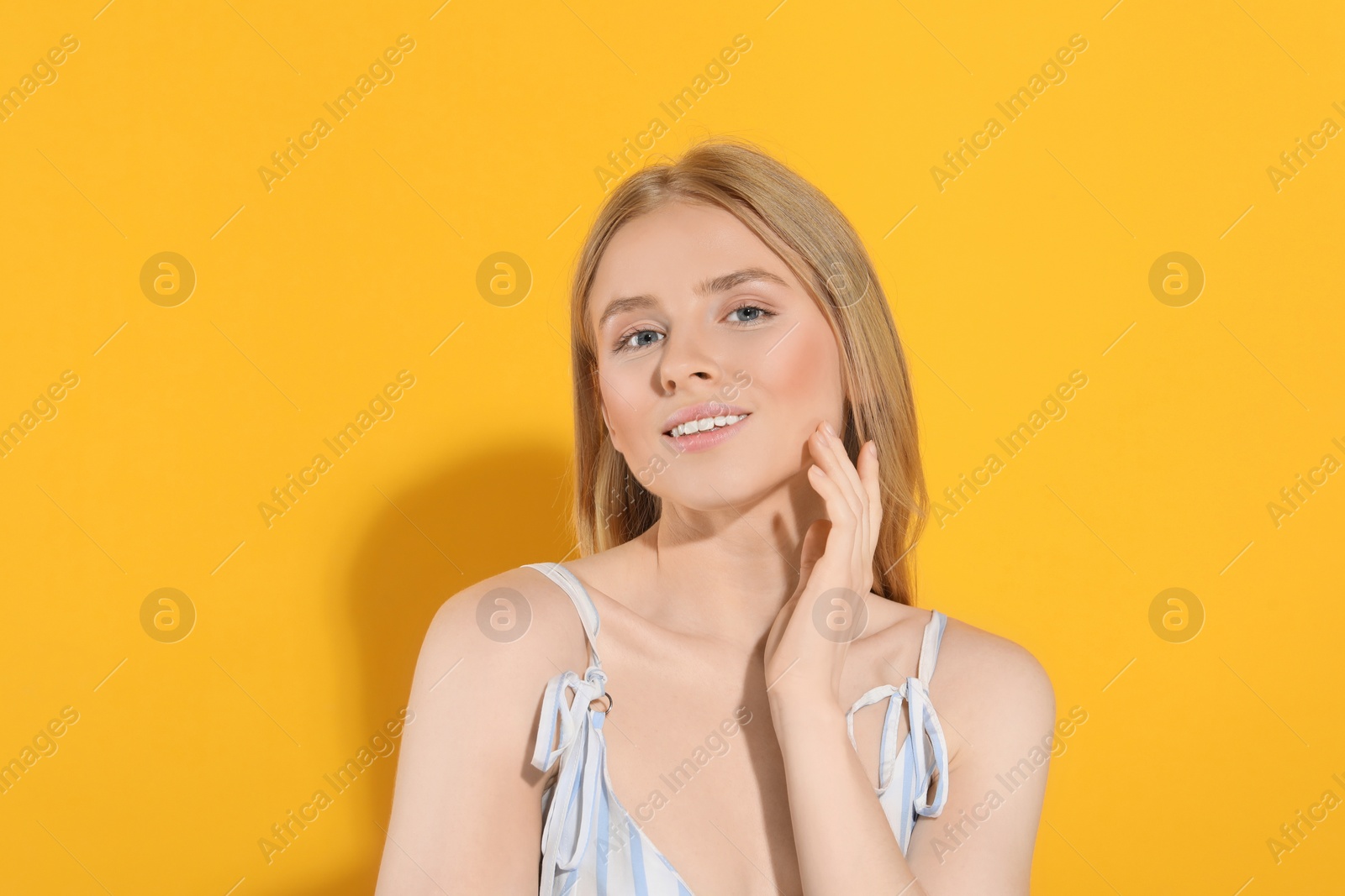 Photo of Beautiful young woman posing on orange background