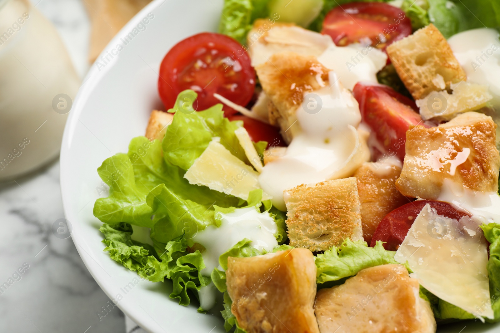 Photo of Tasty Caesar salad with chicken on table, closeup