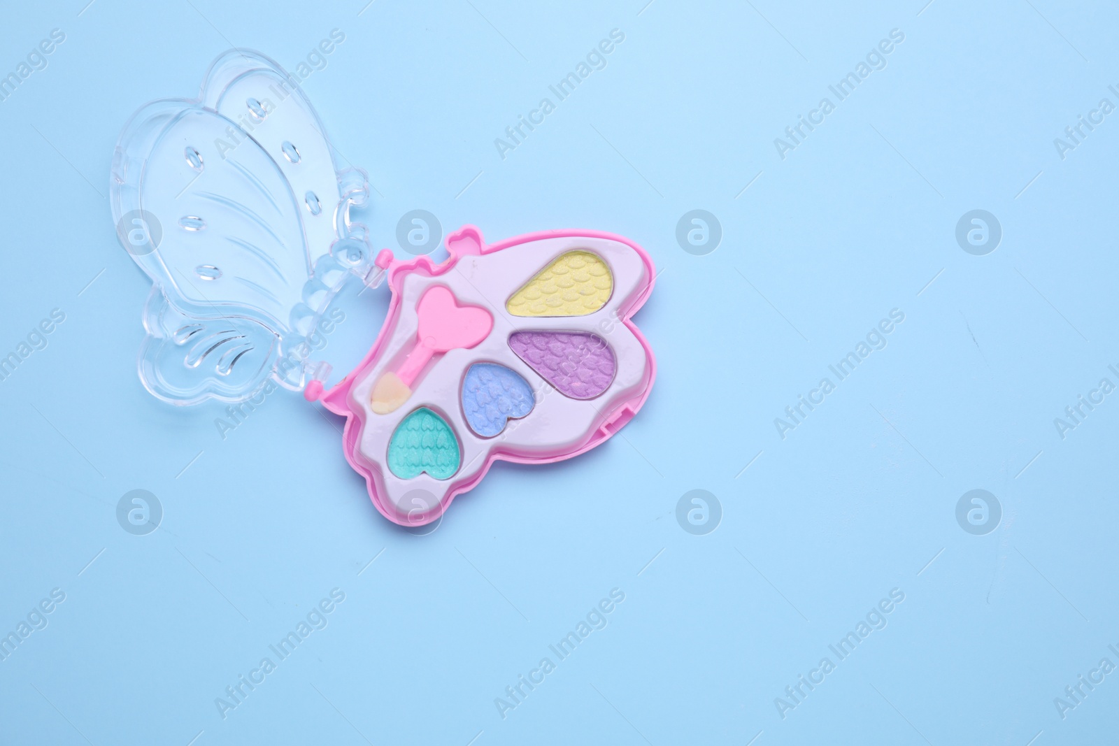 Photo of Decorative cosmetics for kids. Eye shadow palette on light blue background, top view. Space for text