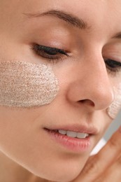 Photo of Woman with cosmetic product on her face, closeup. Spa treatments