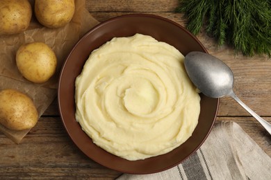 Photo of Freshly cooked homemade mashed potatoes and raw vegetables on wooden table, flat lay