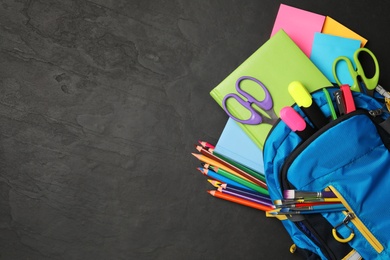 Flat lay composition with different school stationery on black stone table, space for text. Back to school