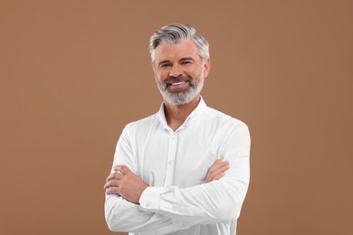 Portrait of smiling man with beautiful hairstyle on light brown background