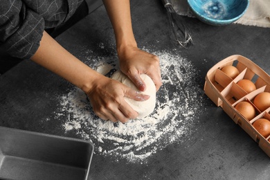 Photo of Woman kneading dough for pastry on table