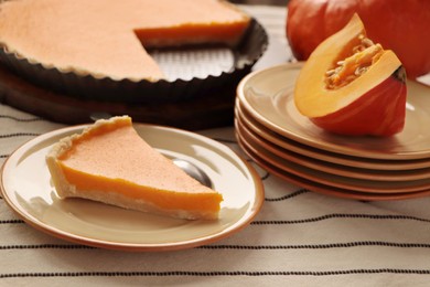 Photo of Plate with piece of homemade pie and fresh pumpkin on table