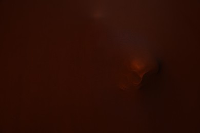 Photo of Silhouette of creepy ghost with skull behind brown cloth. Space for text