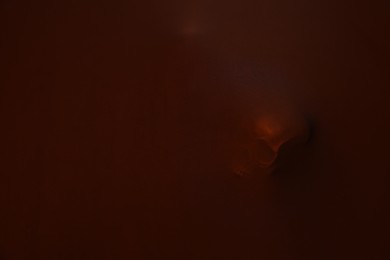 Silhouette of creepy ghost with skull behind brown cloth. Space for text