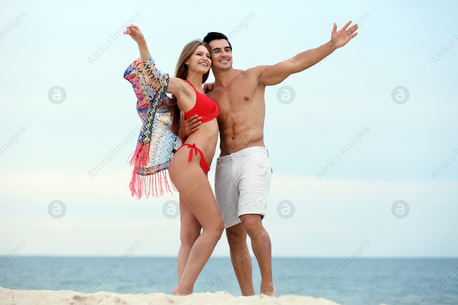 Photo of Happy young couple spending time together on sea beach