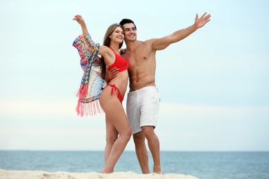 Happy young couple spending time together on sea beach