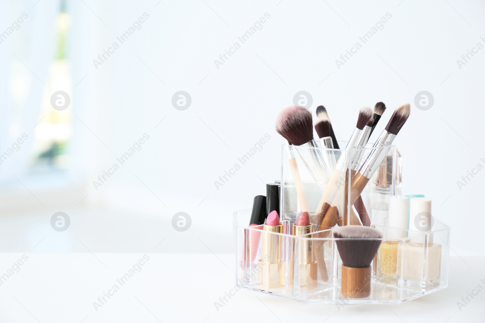 Photo of Organizer with makeup cosmetic products on table indoors. Space for text