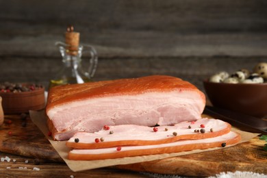 Photo of Delicious smoked bacon with spices on wooden table, closeup