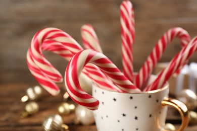 Photo of Sweet Christmas candy canes in cup, closeup