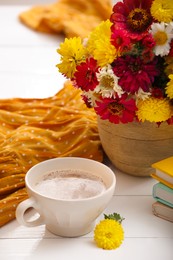 Photo of Cup of fresh coffee and beautiful bouquet on white wooden table. Good morning