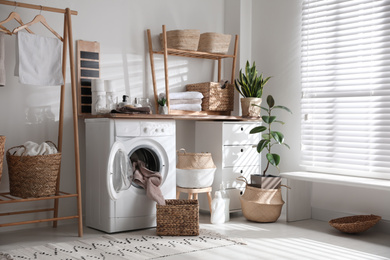 Stylish bathroom interior with modern washing machine