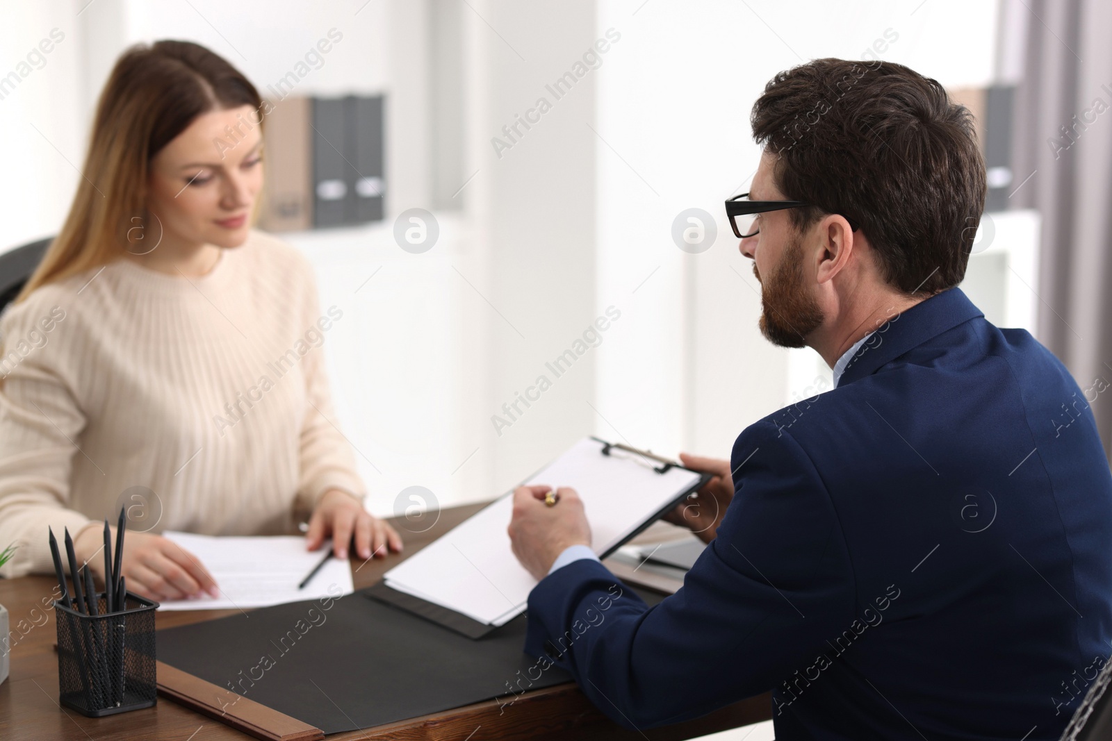 Photo of Woman having meeting with lawyer in office, selective focus