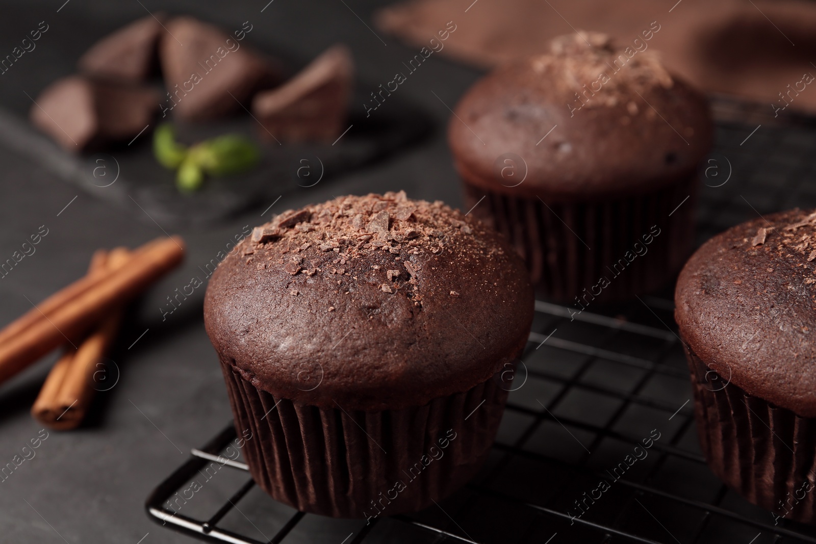 Photo of Delicious chocolate muffins on black table, closeup