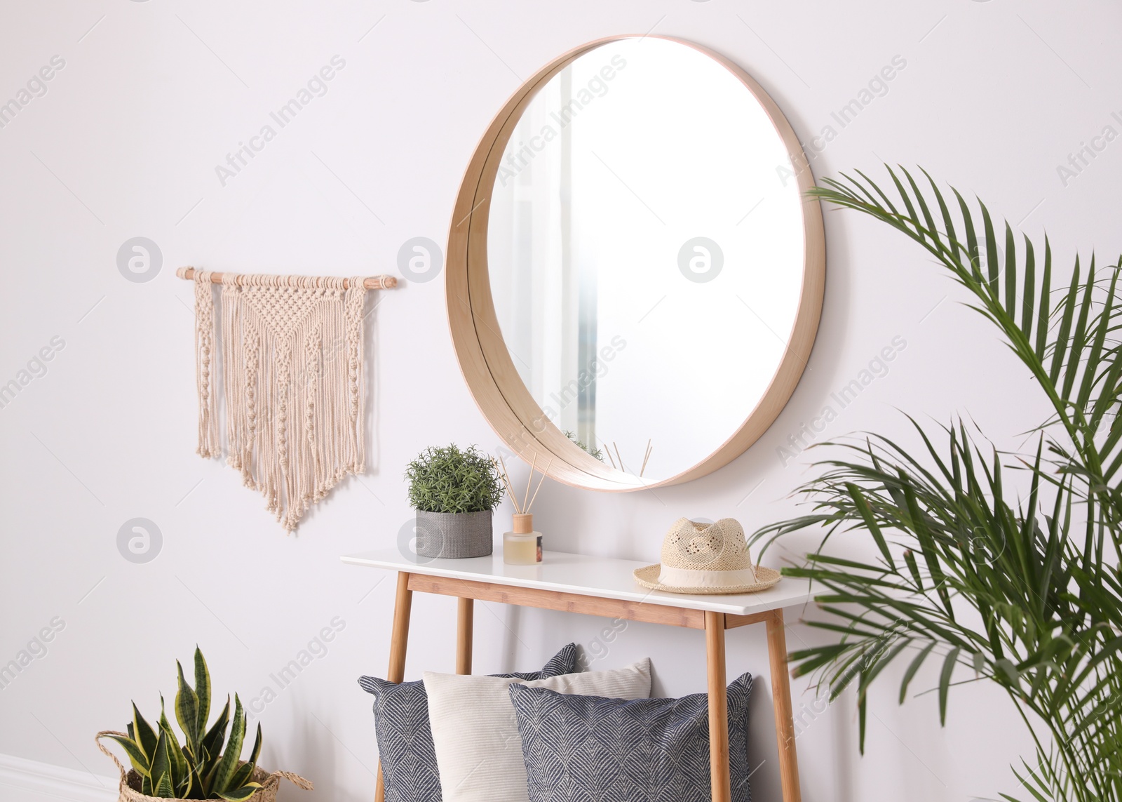 Photo of Round mirror and wooden table at home. Idea for interior design