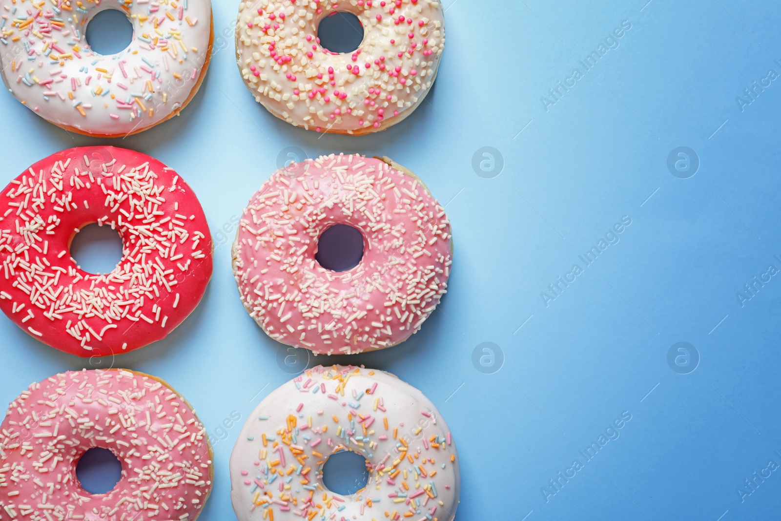 Photo of Delicious glazed doughnuts on color background, top view