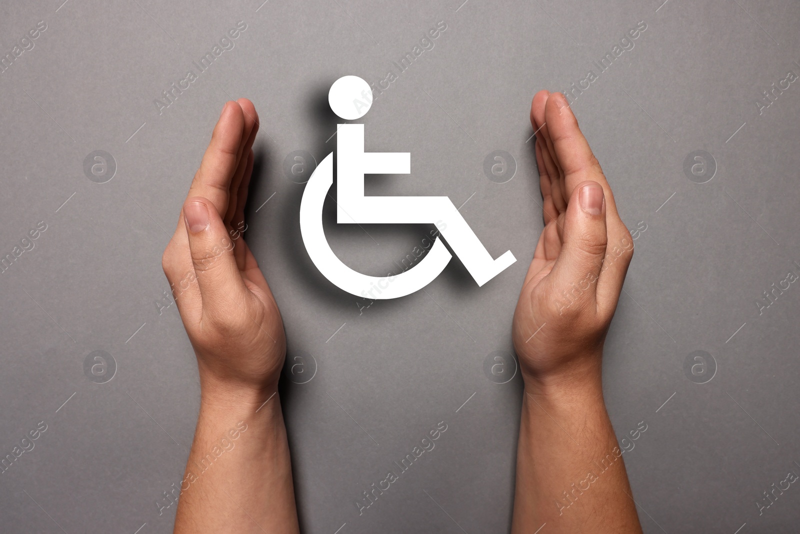 Image of Disability inclusion. Woman protecting wheelchair symbol on grey background, closeup