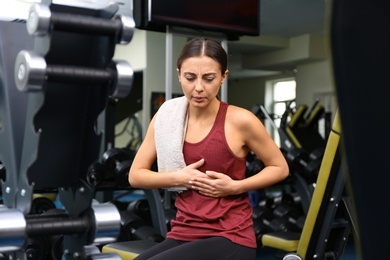 Young woman having heart attack in gym