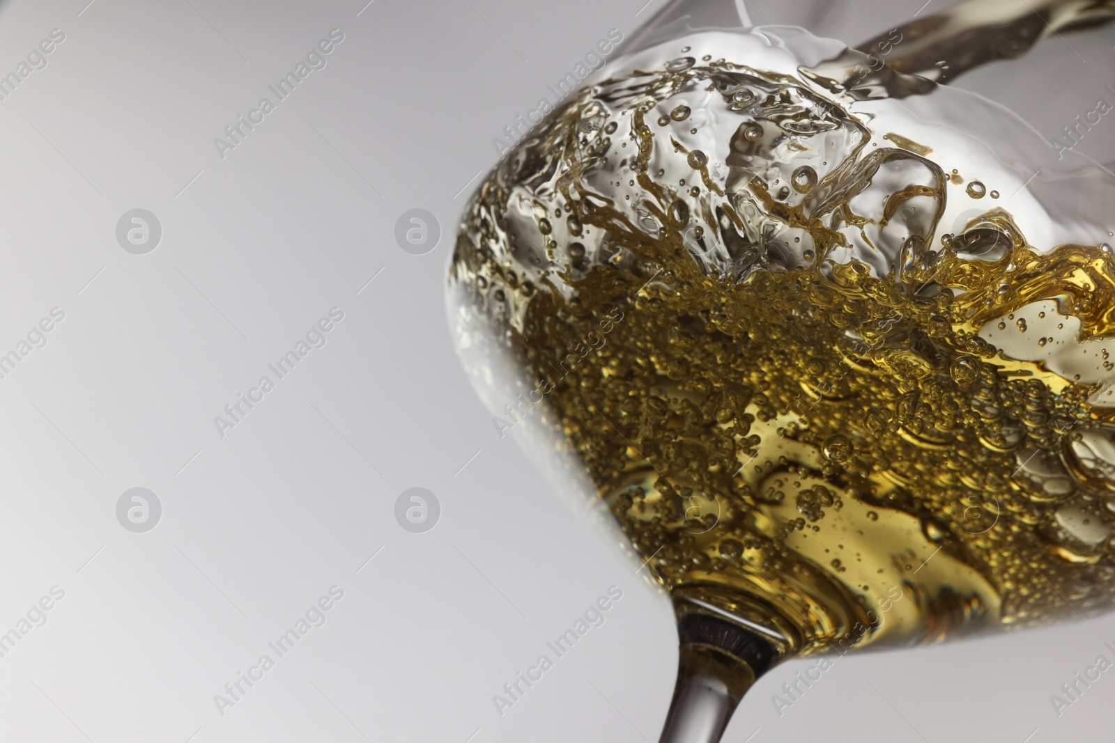 Photo of Tasty aromatic wine in glass on gray background, closeup. Space for text