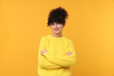 Photo of Happy young woman in stylish warm sweater on yellow background