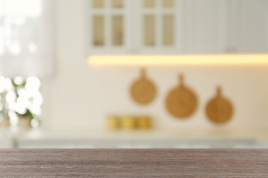 Empty wooden table and blurred view of stylish kitchen interior. Mockup for design