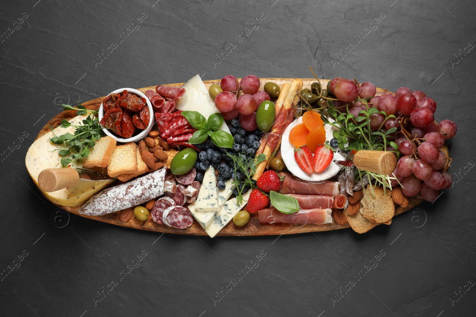 Photo of Set of different delicious appetizers served on black table, top view