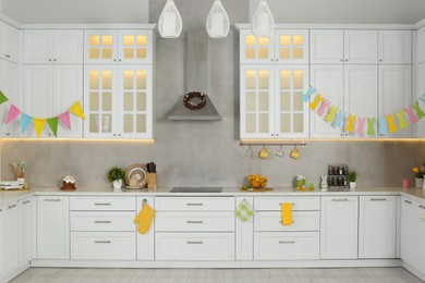 Photo of Stylish white kitchen with colorful Easter decor