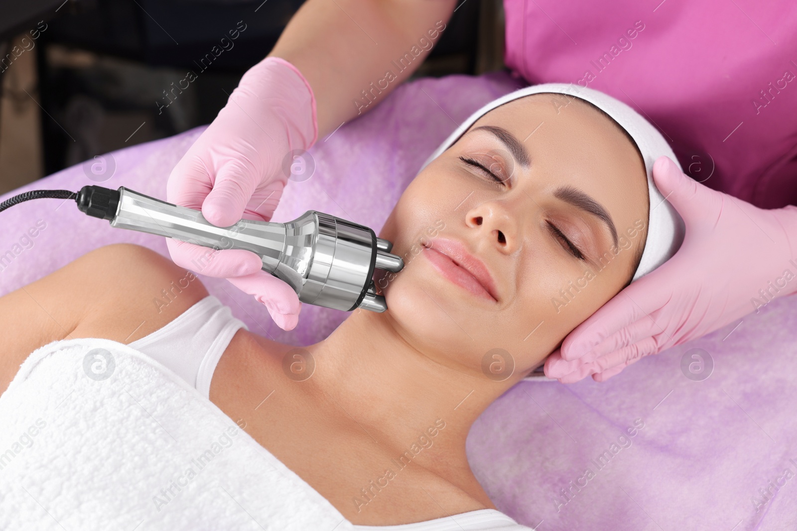 Photo of Young woman undergoing cosmetic procedure in beauty salon. Microcurrent therapy