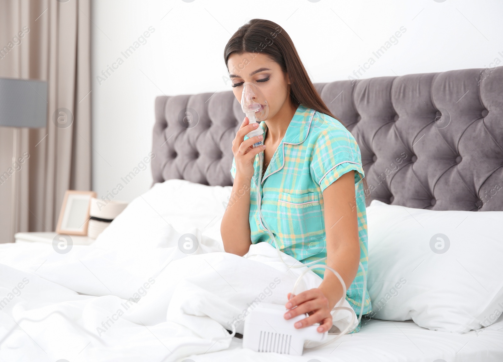 Photo of Woman with asthma machine in light bedroom