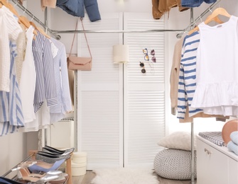 Modern dressing room with different stylish clothes and accessories