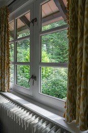 Photo of Old fashioned window with beautiful curtains in room. Interior design