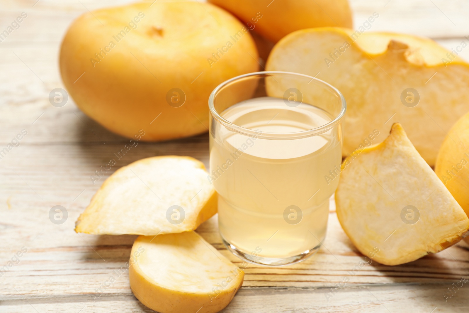 Photo of Glass of freshly made turnip juice on white wooden table