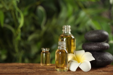 Beautiful composition with aroma oil and spa stones on wooden table. Space for text