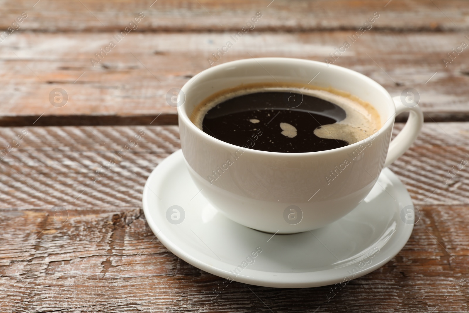 Photo of Cup of aromatic coffee on wooden table, closeup. Space for text