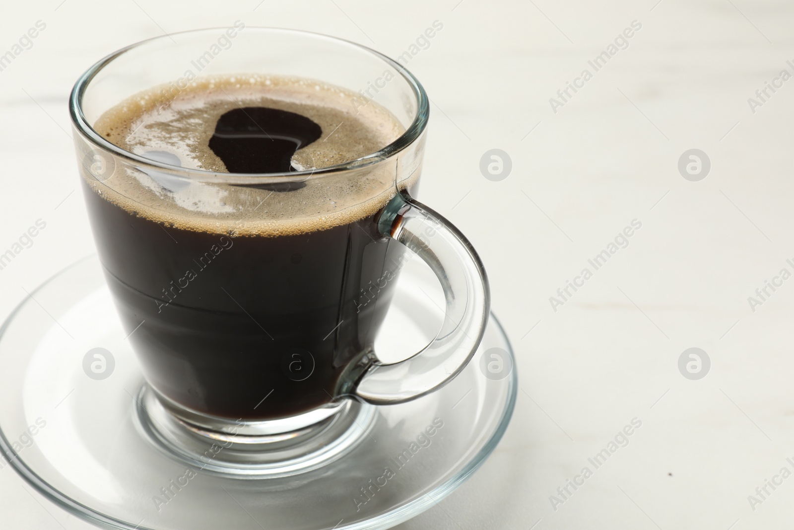 Photo of Cup of aromatic coffee on white table, closeup. Space for text