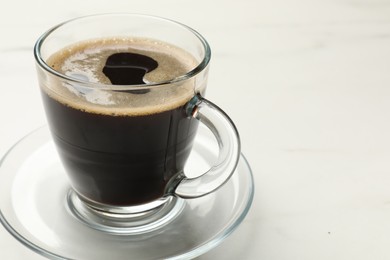 Photo of Cup of aromatic coffee on white table, closeup. Space for text