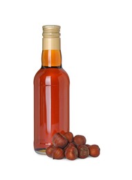 Photo of Bottle of delicious syrup for coffee and hazelnuts isolated on white