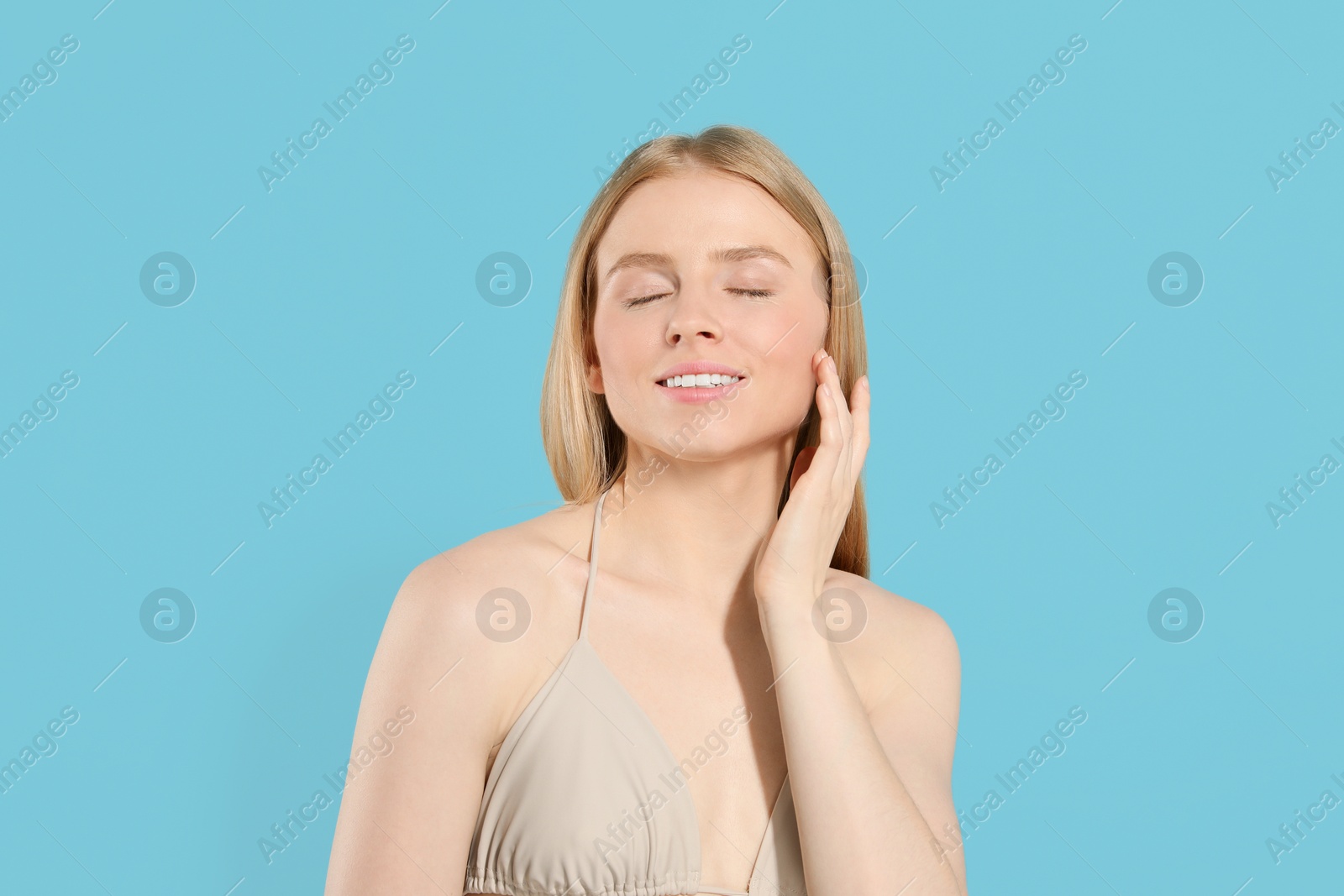 Photo of Beautiful young woman posing on light blue background