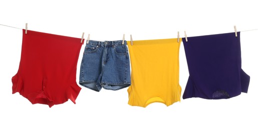 Photo of Different clothes drying on laundry line against white background