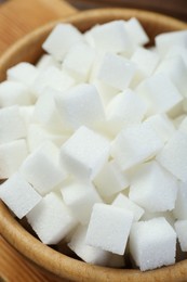 White sugar cubes in wooden bowl, closeup