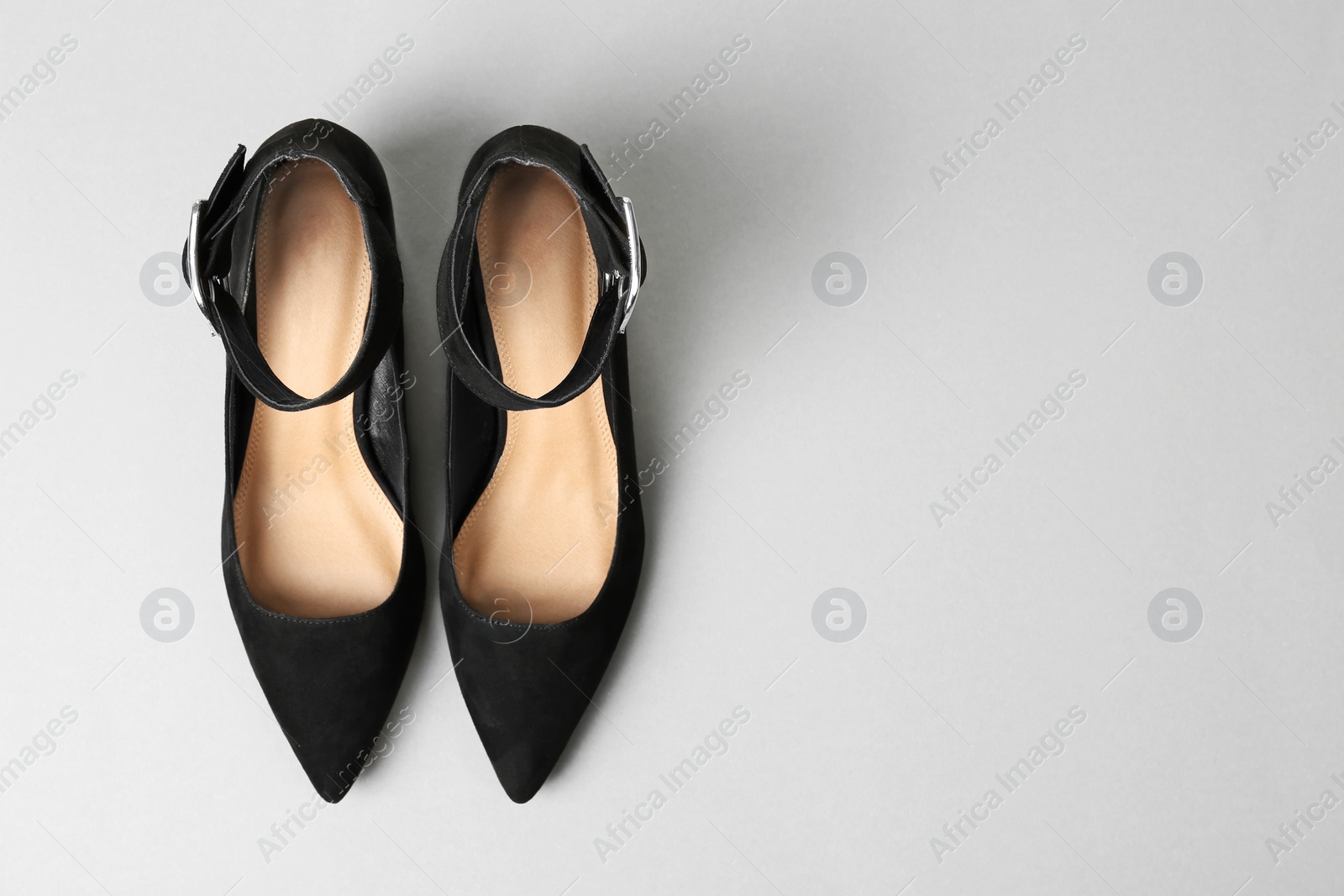 Photo of Pair of female shoes on light background, top view