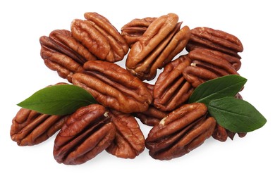 Photo of Many tasty pecan nuts with green leaves isolated on white, top view