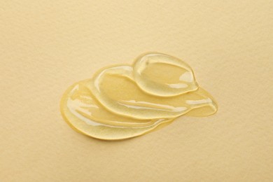 Photo of Swatches of cosmetic gel on beige background, top view