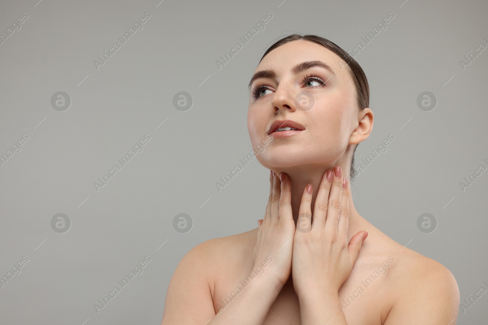 Photo of Beautiful woman touching her neck on grey background. Space for text