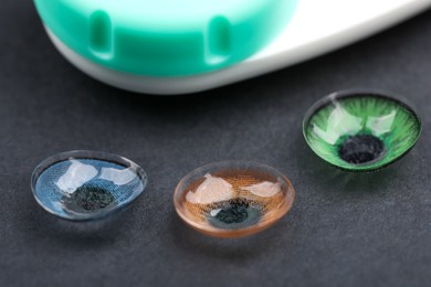 Photo of Different color contact lenses on grey background, closeup