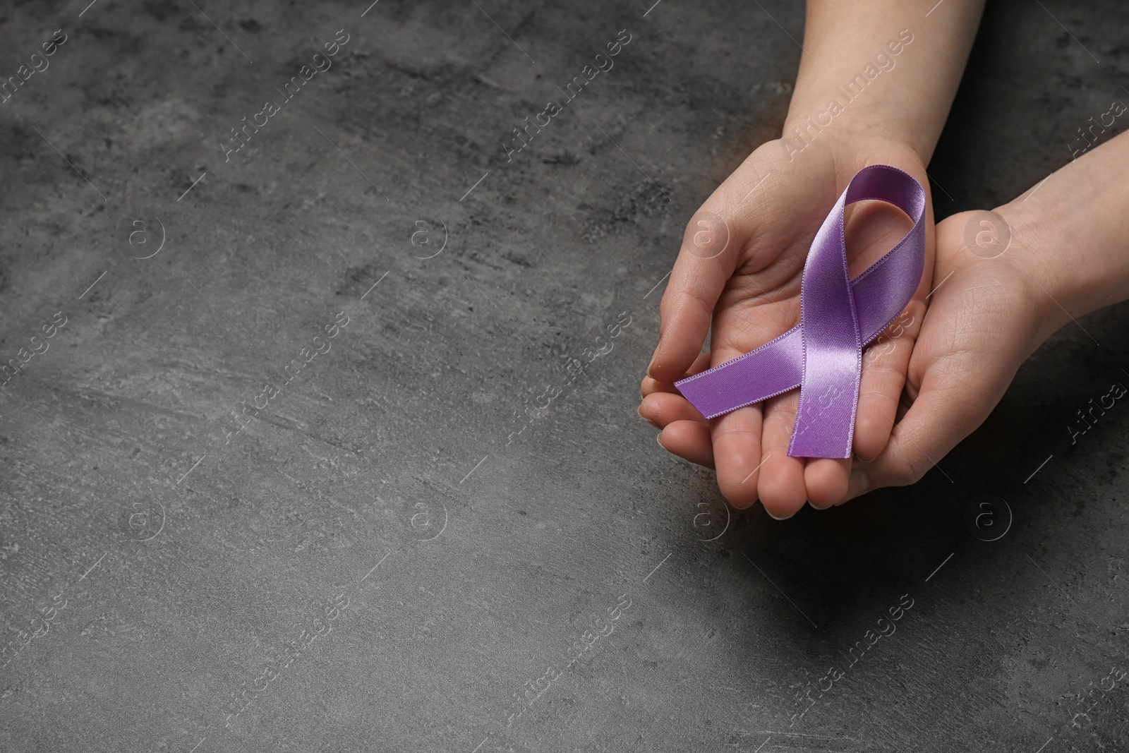 Photo of Woman holding purple awareness ribbon on grey background, space for text