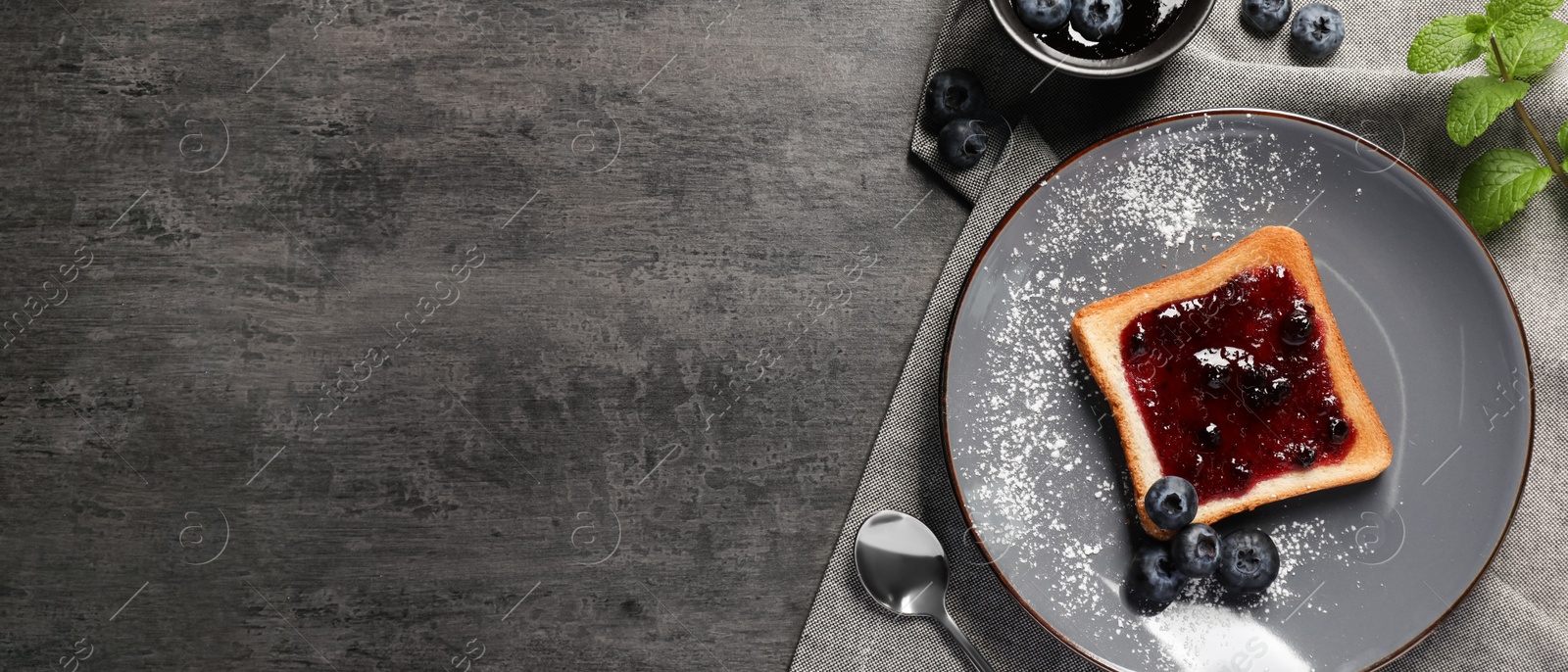 Image of Delicious toast served with jam and blueberries on grey wooden table, flat lay with space for text. Banner design